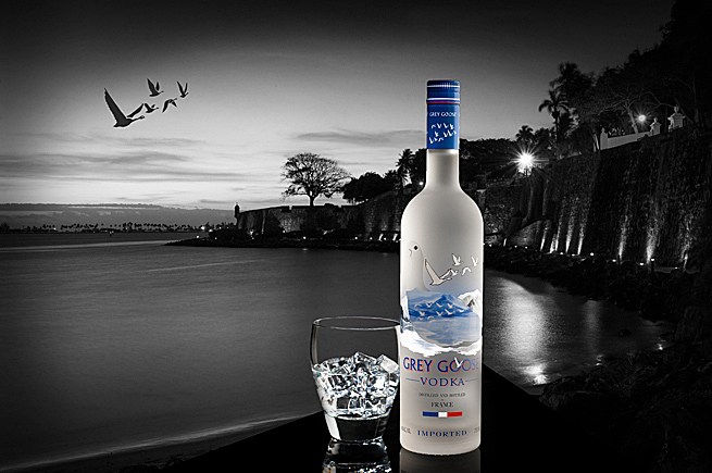 Grey Goose vodka bottle and glass composited into dramatic waterfront scene for high-end commercial beverage photography.